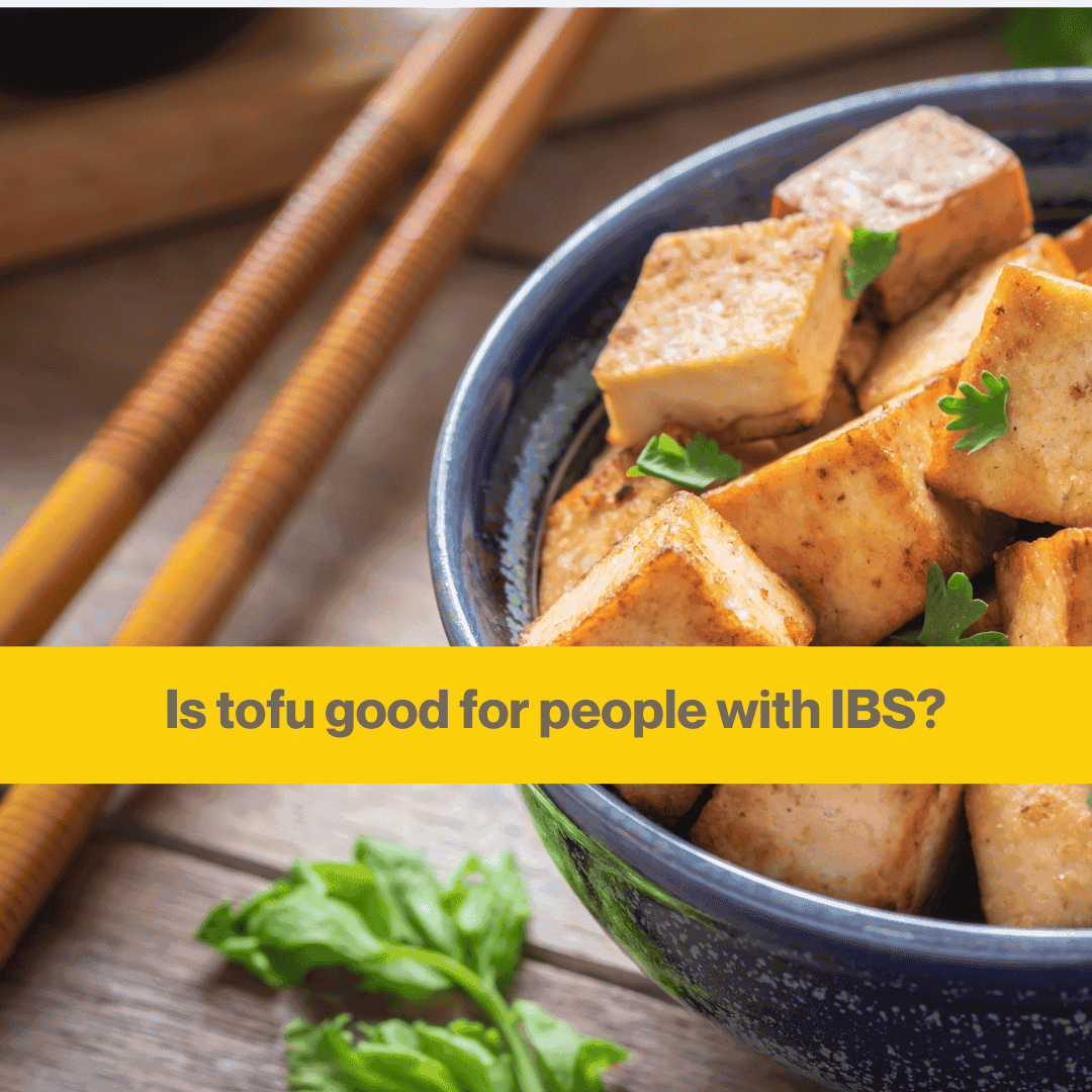 Blue china bowl with lumps of fried tofu, some wooden chopsticks are resting on the table next to the bowl